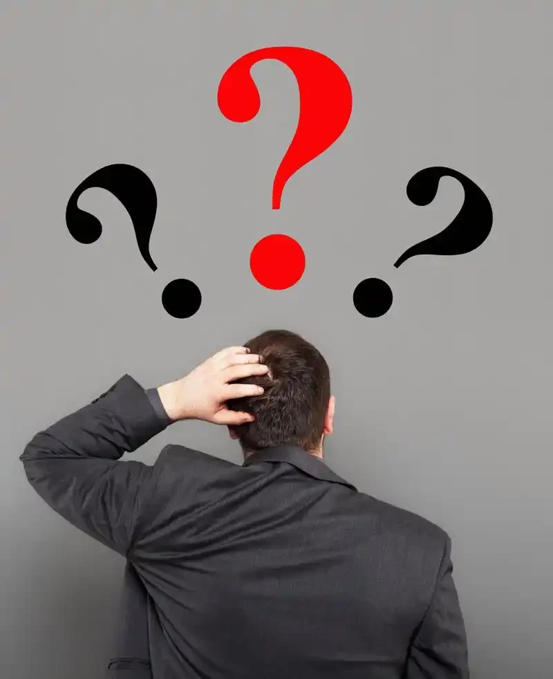 Businessman seen from behind facing question marks, representing supplier uncertainty